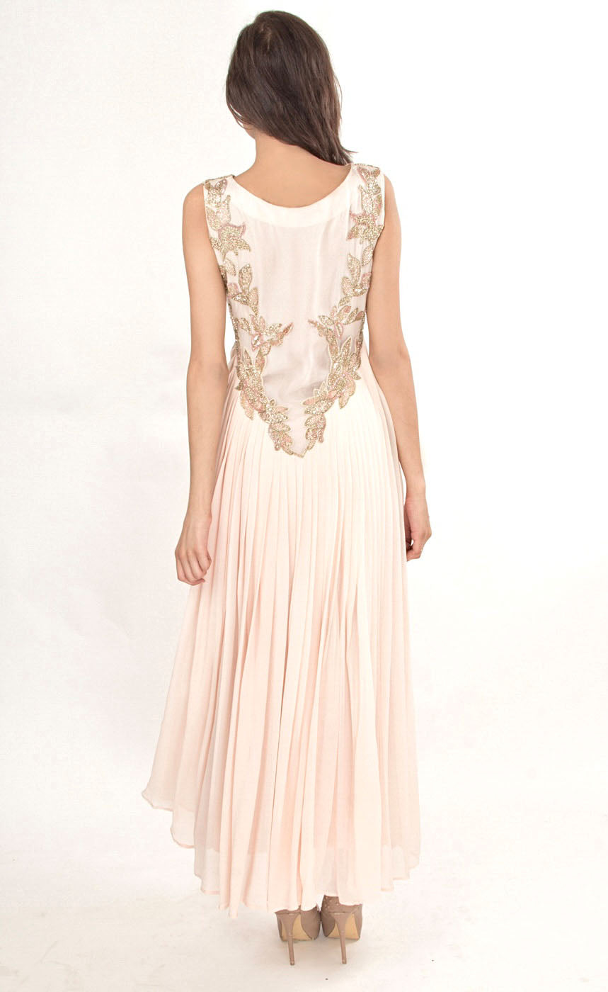 The muse here is wearing our powder pink gown. This gown is fully embroidered with beads, sequins and gold work on the front as well as the back. It beautifully gathers around the waist creating an elegant flare for you when you walk. This classic gown with it's comforting style is a perfect companion for an evening event needs. 