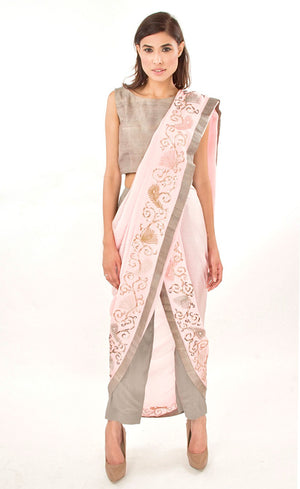 The muse here is wearing our rose pink ready to wear dhoti sari drape with trousers. It is a playful look to spice up your traditional game into something really trendy. This comprises of a silk chiffon dhoti sari drape intricately embroidered with hand by using silk threads, sequins and silver work along the fall and pallu of the sari which is further paired with a simple and elegant raw silk crop-top and slim crepe trousers. 