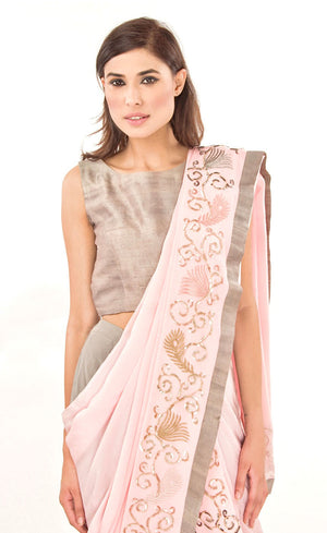 The muse here is wearing our rose pink ready to wear dhoti sari drape with trousers. It is a playful look to spice up your traditional game into something really trendy. This comprises of a silk chiffon dhoti sari drape intricately embroidered with hand by using silk threads, sequins and silver work along the fall and pallu of the sari which is further paired with a simple and elegant raw silk crop-top and slim crepe trousers. 